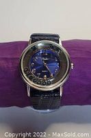 Clear frontal photo of Milano watch showing the blue dial with bead hour markers and decorative beads, silver-tone case, and blue leather strap.