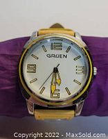 Front view showing the Gruen brand watch with white face, yellow leather strap, and silver-tone bezel.