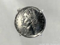Top view of the ring showing the detailed profile of the Roman figure and coin markings on the Italian 100 Lire coin dated 1957.
