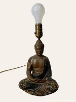Front view of antique Buddha statue lamp with light bulb