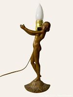 Front angle of the Art Nouveau antique lamp showing the figural female nude base with light bulb attached, cord visible.