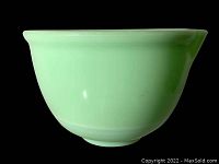 Side view of opaque jadeite glass mixing bowl showing smooth pale green surface and rounded shape.