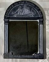 Front view of mirror shaped like 18th century headstone with engraving of U.S.S. Trumbull frigate, text states 'Anchor'd in the haven of Rest' and 'U.S.S. TRUMBULL 1780'.