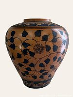 Front view of hand painted terra-cotta urn showing floral vine pattern.