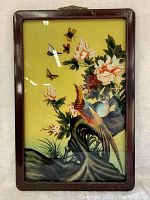 Front view of antique reverse painting on glass depicting birds, butterflies, and flowers in a wood frame.