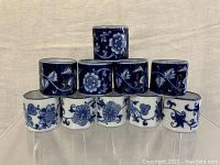 Ten ceramic napkin rings arranged in a pyramid, alternating blue and white floral patterns.