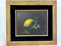 Frontal view of framed painting showing lemon and berries still life