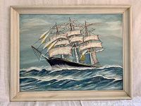 Front view of the oil painting showing a sailing ship on water with a cloudy sky background, framed in a white frame.