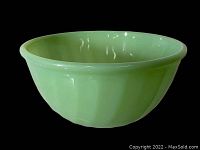 Photo of the vintage Fire King Jadeite bowl showing the interior and exterior in a black background.