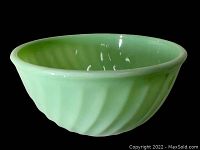 Side angle showing the opaque pale green jadeite hump-backed bowl with swirl pattern on exterior.