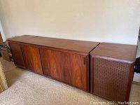 Front view of walnut console with sliding doors and attached side speakers