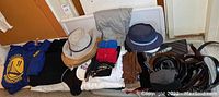 Photo showing a variety of men's and women's clothing items including Golden State Warriors t-shirts, sweatshirts, hats, belts, scarves, gloves, socks, sweaters, new dress shirt, and tie.