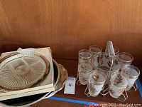 Photo showing stacked trays and silver colored carrier with glasses and ice bucket