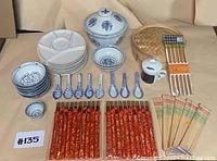 Full layout of Asian dish set including all bowls, spoons, tea mug, steamer, plates, and chopsticks.