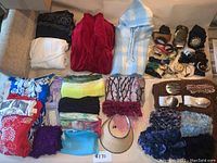 Full lot overview showing scarves, belts, and accessories spread on floor and shelf