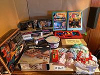 Full lot overview showing Barbie dolls, Lite-Brite refill packs, doll clothes, game chest, Play Rail Merry-go-copter, Duplo blocks, jumbo chalk