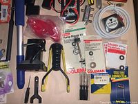 Top-down view showing Huskey bits, plumbing repair kits, hand tools including wrenches and clamps, and electrical wire.