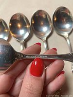 Close-up of spoon handle showing 'International Sterling' maker’s mark and floral detail