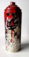 Front view showing red drips and abstract black-and-white motifs over speckled white background