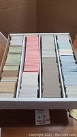 Photo showing large box holding about 3000 organized baseball cards separated in sections by color.