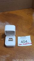 Ring shown inside white presentation box with lot tag visible
