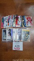 Lot of about 50 hockey cards spread in two stacks, mix of old and new cards visible including a vintage style Michel Dion card.