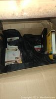 Box containing VHS tapes and a bag with CDs inside. Visible are BASF VHS tape boxes and some loose VHS cassettes.