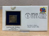 Front view of the commemorative card containing the gold plated replica Superman stamp and the First Day of Issue postmark.