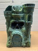 Front view of Castle Greyskull with skull facade and closed door.