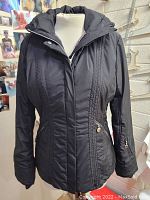 Front view of black Calvin Klein womens jacket on mannequin showing zip front and detailed stitching