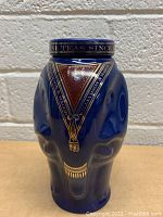 Front view of the dark blue elephant-shaped tea jar with gold detailing and text on the lid and sides.