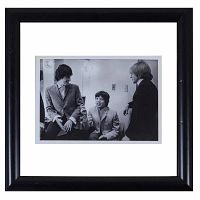 Framed black and white photograph showing three men backstage in a candid moment, framed in a black frame with white matting.