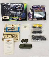 Full lot display showing Star Wars Final Jedi Duel boxed set, Corgi Fighter Scramble plane, American Heritage card set, model trains, and military vehicles.