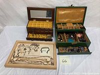 Overall overview of two jewelry boxes and a wooden tray containing assorted costume jewelry, showing necklaces, bracelets, earrings, and pendants.