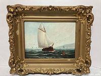 Frontal view of oil on canvas painting showing a red sailboat and buoy on the ocean with an ornate gold frame that displays some light damage.