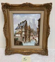 Full view of framed oil on ceramic painting depicting historic European architecture, canal, and covered bridge.