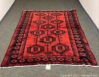 Full view of the rectangular oriental rug laid flat showing overall pattern and color.