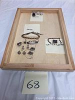 Full tray view showing all jewelry pieces including earrings, bracelets, and brooch with identification labels for sterling and gold filled items.