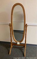 Front view of the oval full-length wooden cheval mirror showing the mirror and frame.
