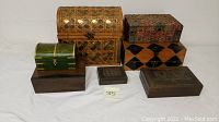 Full set of six decorative wooden vanity boxes arranged on a white surface, showing various sizes, shapes, and styles.