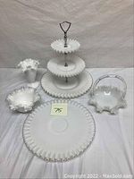 Photo showing all five pieces arranged on a white surface, including the cake stand, platter, basket, ruffled bowl, and tall vase.