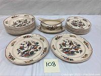Full view of set including 8 dinner plates, 4 bowls, and 1 gravy boat with attached underplate displayed on white surface.