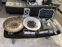 Photo of the ceramic zebra plate, Artistic Accents bowl with black rocks, resin fountain, chalkboard, mirror, and glass vases arranged on table