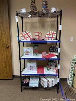 Full view of the black metal wire shelving unit with household items on shelves for scale reference.
