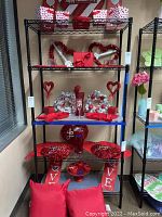 Full view of assembled black metal wire shelf unit with five shelves. Shelves contain decorative Valentine-themed items not included in the lot.