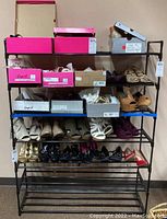 Front view of metal and plastic shoe rack holding several shoe boxes and shoes, showing size and shelving detail