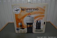 Front view of original packaging showing machine image, brand, and bundle contents along with +$40 coffee capsules offer sticker.