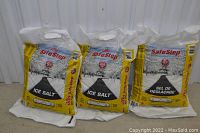 Photo showing 3 sealed bags of SafeStep ice salt, each weighing 20 kg, with bilingual labeling and yellow/white packaging.