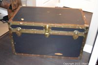 Front view of the antique wooden chest showing dark blue body with yellow colored metal edges and latches