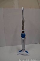 Front view of white BISSELL PowerFresh 2-in-1 Hard Floor Steam Mop Cleaner standing upright on a white surface, showing handle, water tank, and mop head.